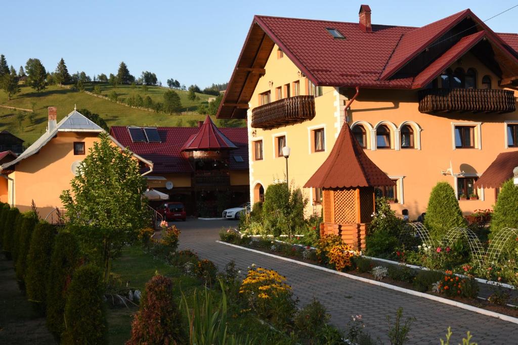 ein Haus mit einem roten Dach auf einer Straße in der Unterkunft Pensiunea Casa Cristina in Câmpulung Moldovenesc