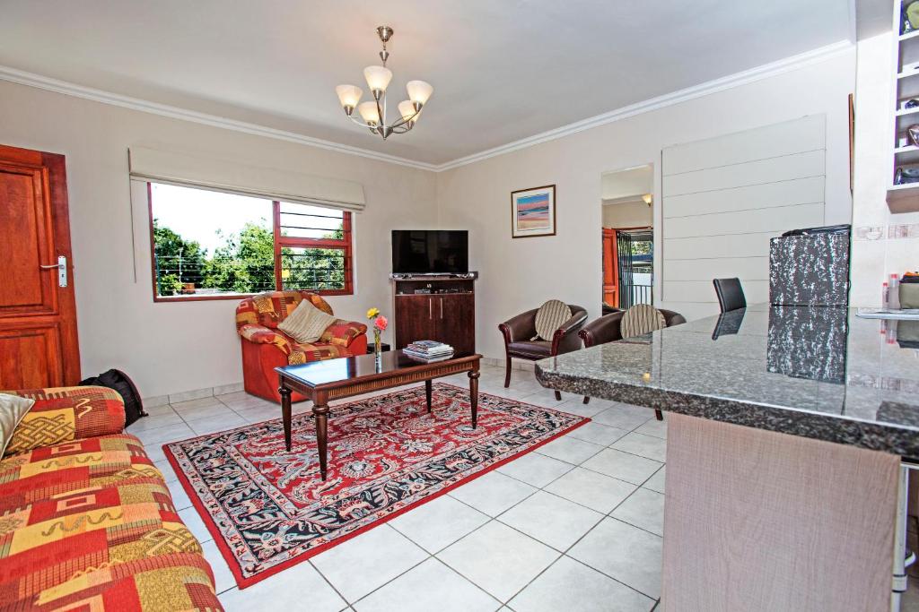 ein Wohnzimmer mit Sofa und Tisch in der Unterkunft Spacious Garden Cottage in Johannesburg