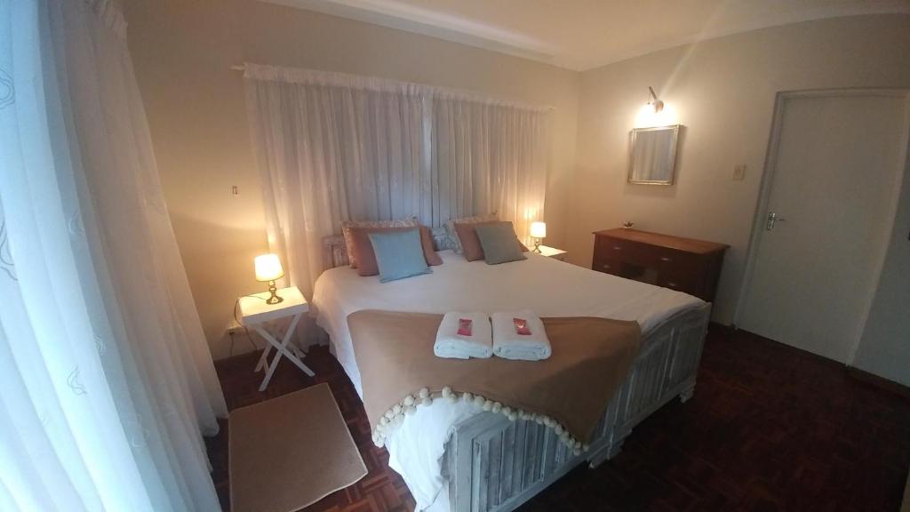 a bedroom with a bed with two towels on it at 36 Mount Road Guesthouse and Self Catering in Port Elizabeth
