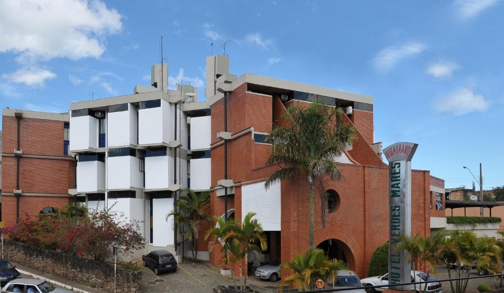 un edificio con una palmera delante de él en Hotel Verdes Mares, en Ouro Branco
