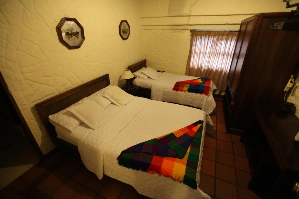Postel nebo postele na pokoji v ubytování HOTEL Quito Antiguo