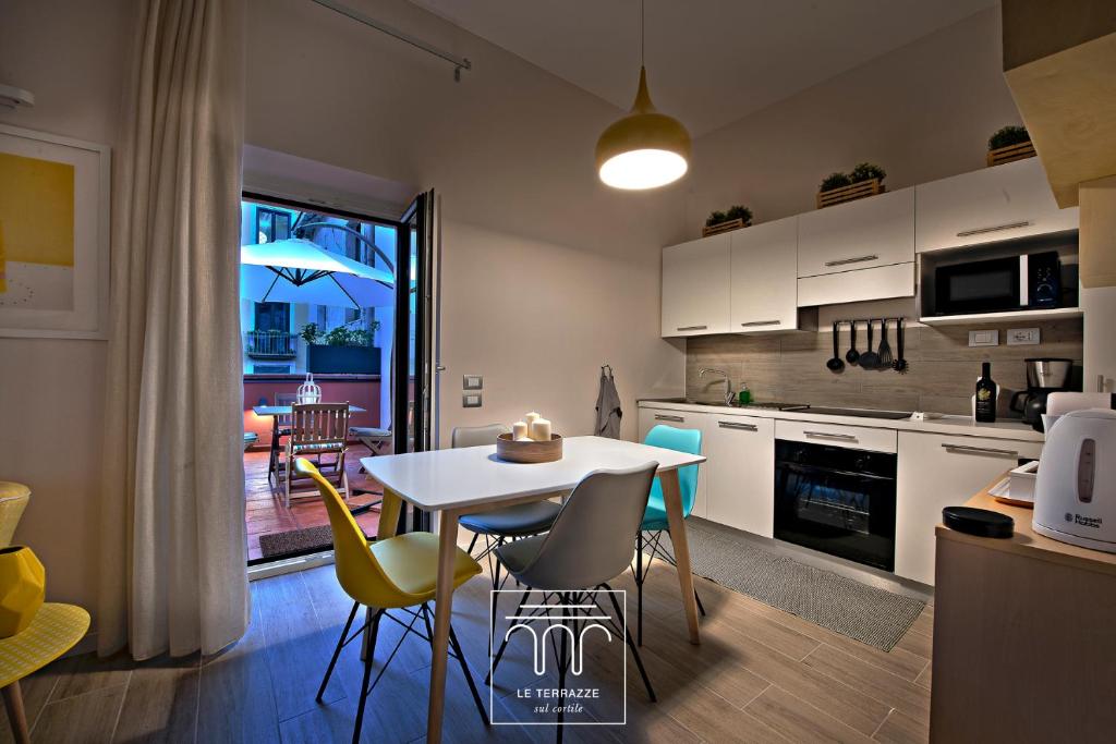 eine Küche und ein Esszimmer mit Tisch und Stühlen in der Unterkunft Le Terrazze sul Cortile in Salerno