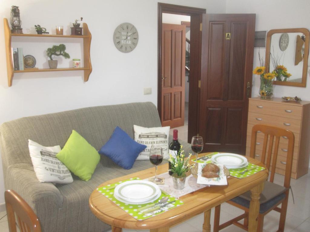 ein Wohnzimmer mit einem Tisch und einem Sofa in der Unterkunft Estudio Casco Los Silos, cerca de Garachico in Los Silos