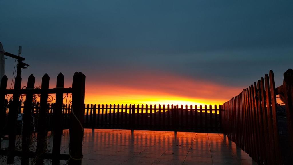 a fence with the sunset in the background at La Locanda dei Cavalieri Affittacamere in Lugagnano Val dʼArda