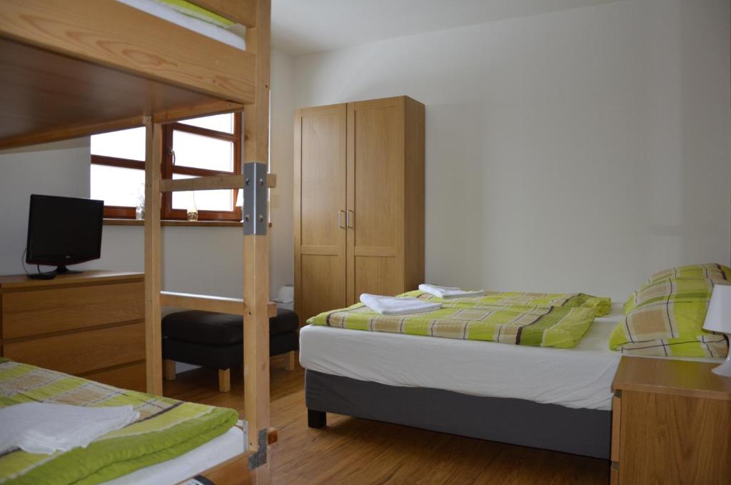 a bedroom with two bunk beds and a television at Apartmán v Srdci Hor Cihlářka in Pec pod Sněžkou