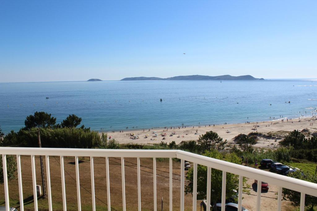 uma vista para a praia a partir de uma varanda em Hotel Mar Azul em A Lanzada