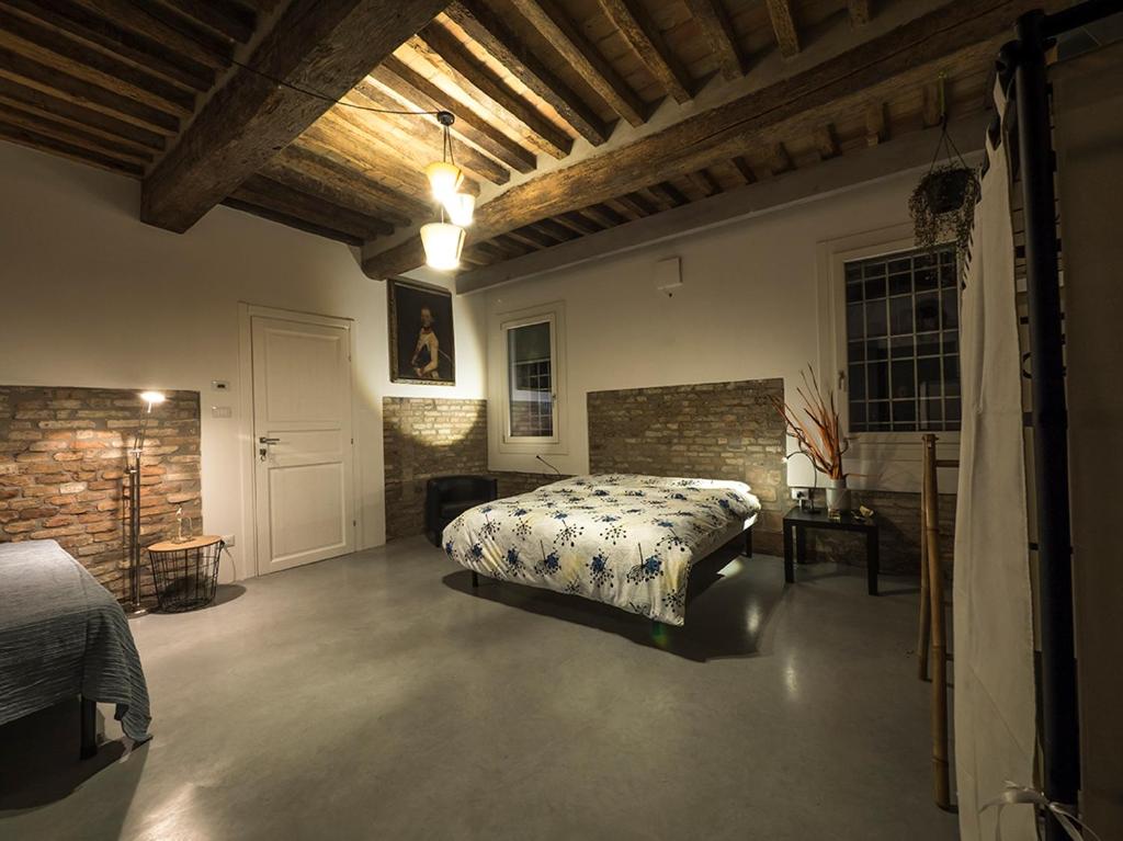 1 dormitorio con cama y pared de ladrillo en Zucchero sui Baffi- Food Lovers B&B en Mantova