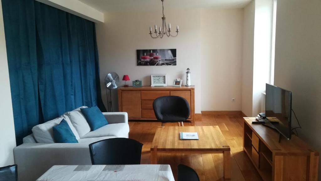 a living room with a couch and a table at Un Joli Pied a Terre in Montignac