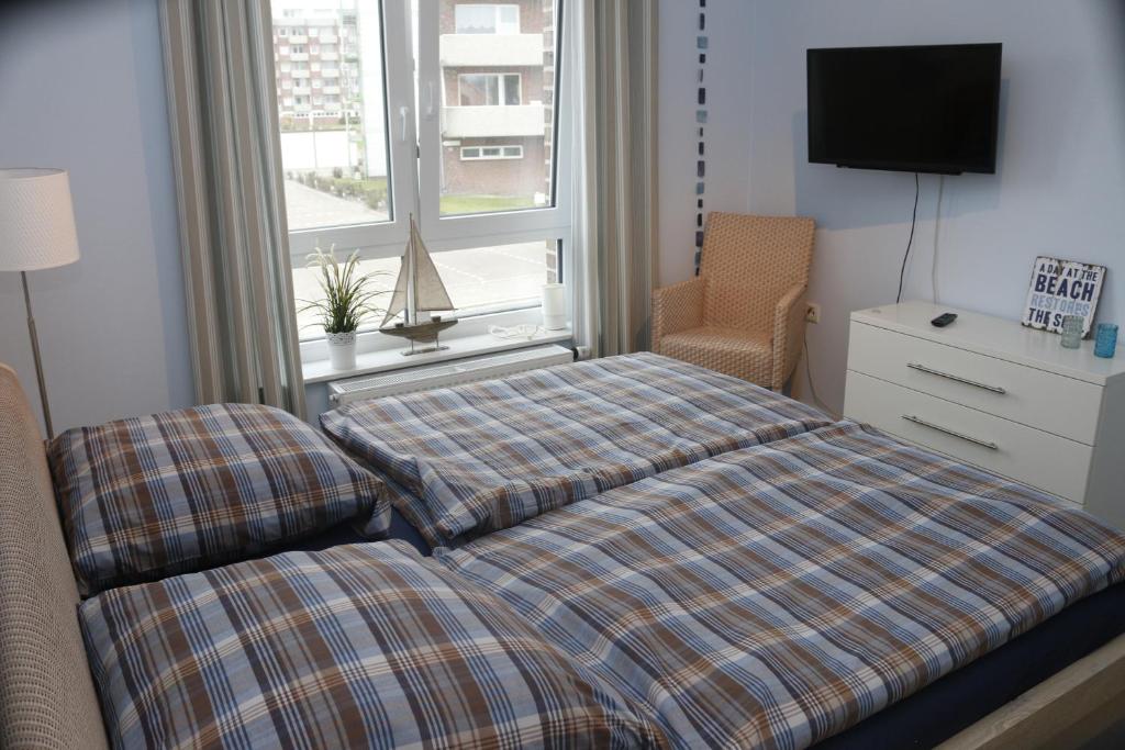 sypialnia z łóżkiem i oknem w obiekcie Strandgut w mieście Horumersiel