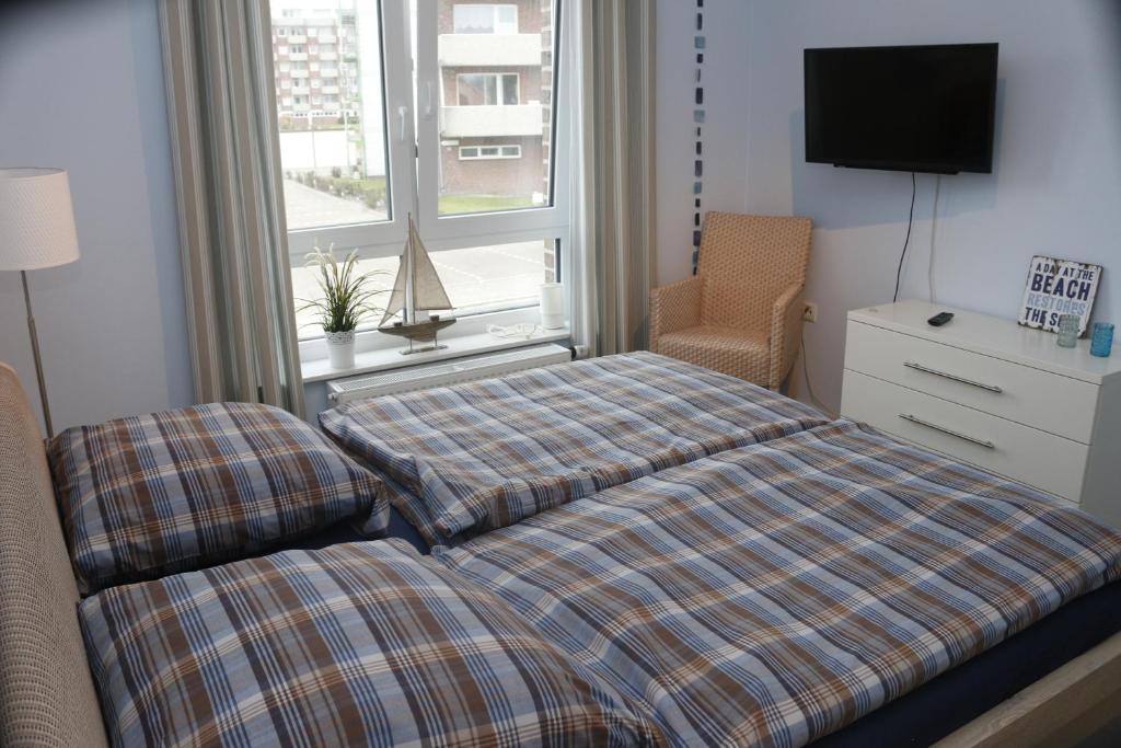 a bedroom with a bed and a window at Strandgut in Horumersiel
