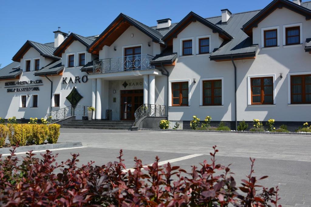 Un grand bâtiment blanc avec de nombreuses fenêtres dans l'établissement Hotel KARO, à Radom