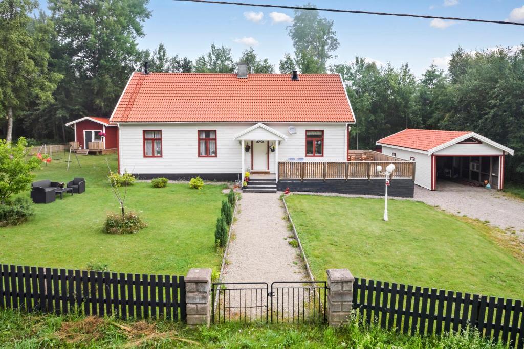 una piccola casa bianca con tetto rosso di Ferienhaus am Mycklaflon a Eksjö