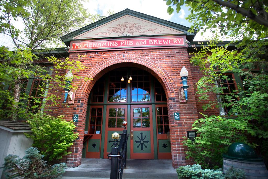 ein rotes Backsteingebäude mit einer Tür mit einem Schild darauf in der Unterkunft McMenamins Old St. Francis School in Bend