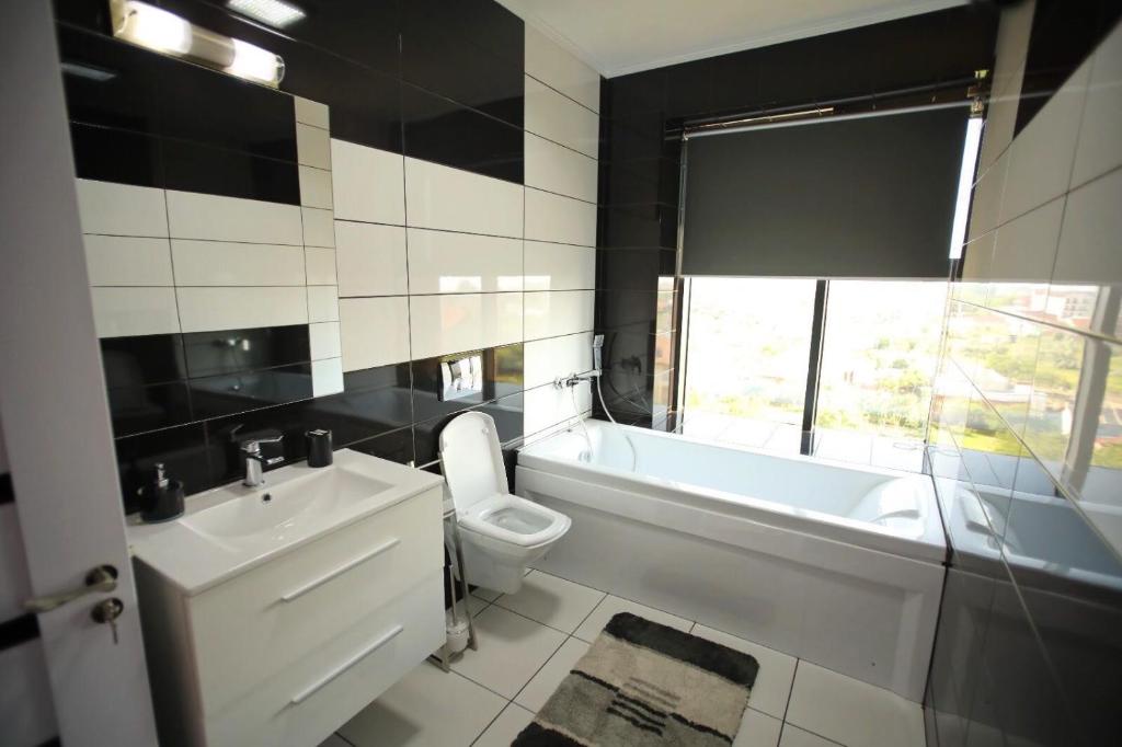 a bathroom with a sink and a tub and a toilet at Hotel Sweet in Mamaia Nord