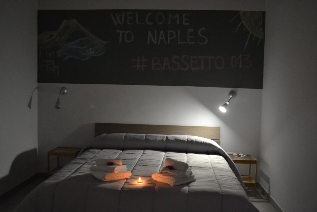 sypialnia z łóżkiem z napisem na ścianie w obiekcie Bassetto 013 w mieście Napoli