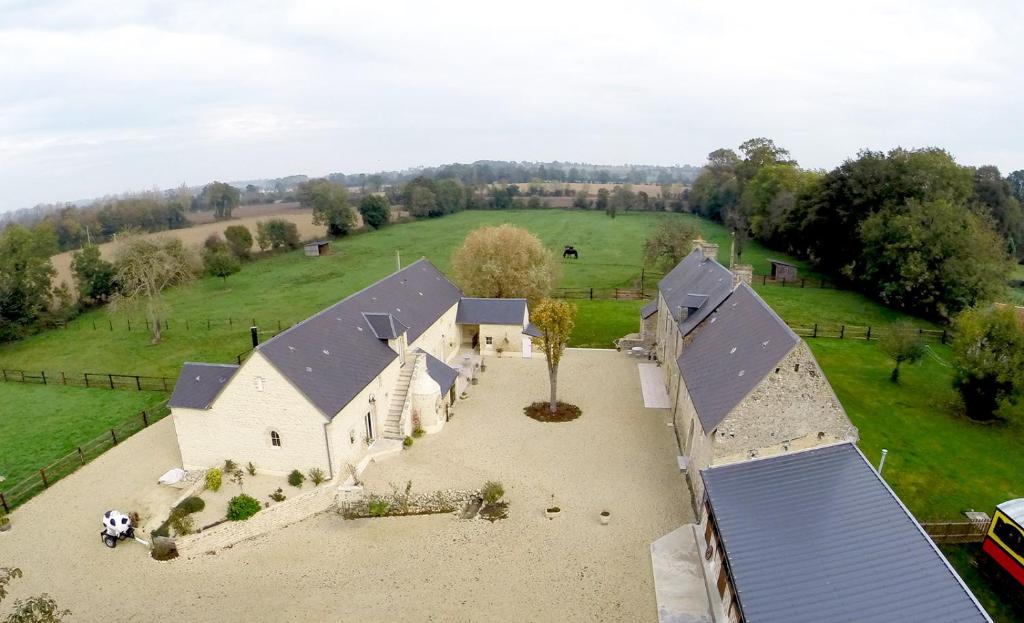 una vista aerea di una grande chiesa bianca con un pallone da calcio di Les Pérelles a Saint-Vigor-le-Grand
