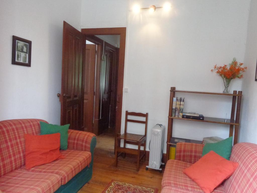 una sala de estar con 2 sofás y una silla en Sol Nascente, en Coímbra