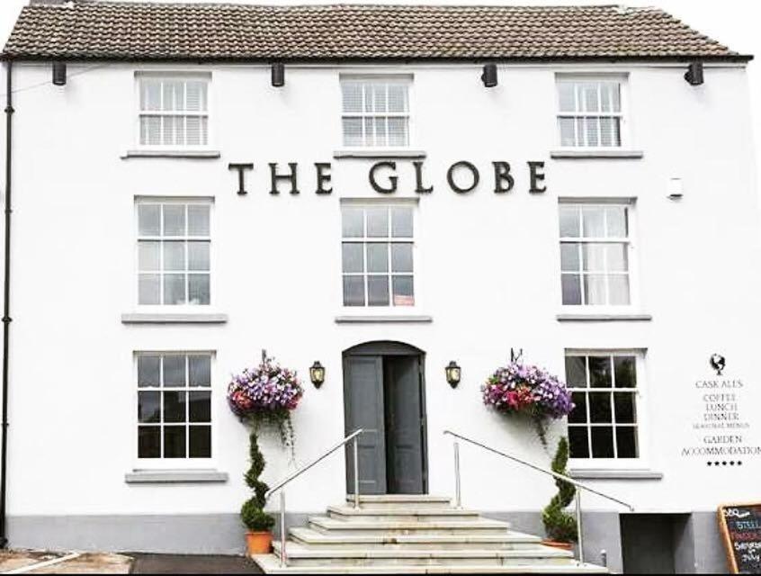 a white building with the globe sign on it at The Globe Inn Alvington in Alvington