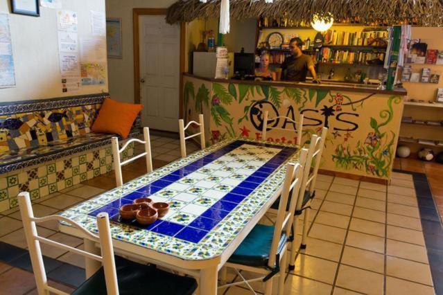 プエルト・バジャルタにあるOasis Hostelのレストランのテーブルと椅子付きのキッチンが備わります。