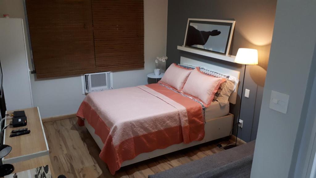 małą sypialnię z łóżkiem z różowymi poduszkami w obiekcie Loft Copacabana Avenida Atlantica w mieście Rio de Janeiro