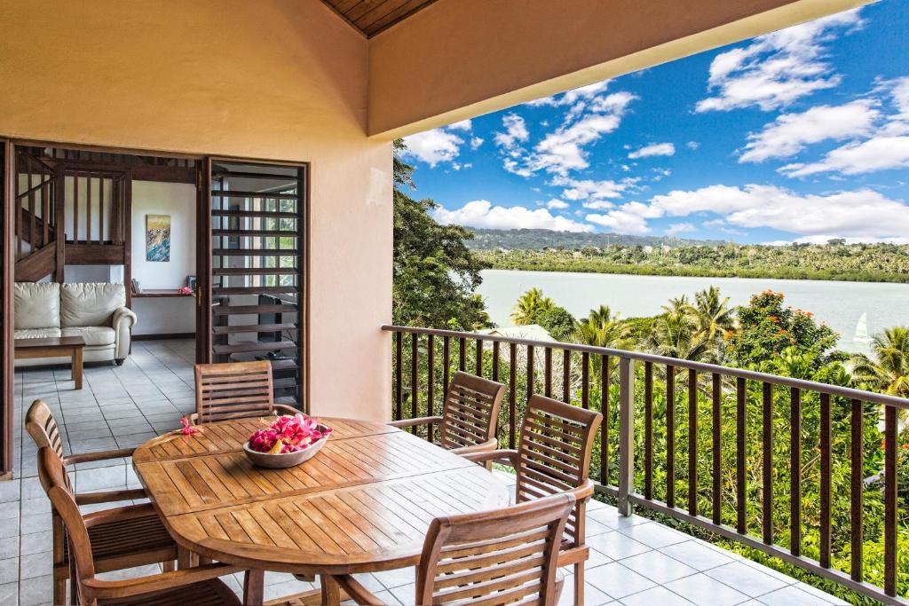 a balcony with a table and chairs and a view of the water at Poppy's on the Lagoon in Port Vila