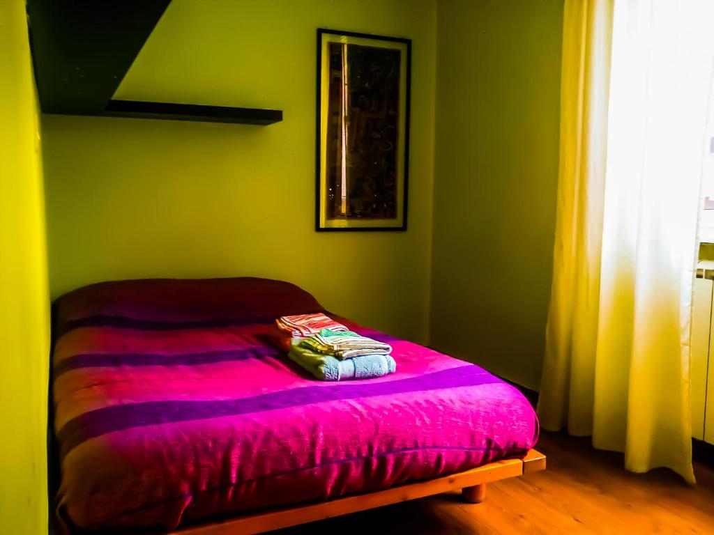ローマにある4321 B&B Stazione Trastevereのピンクの毛布が備わる緑の部屋のベッド1台