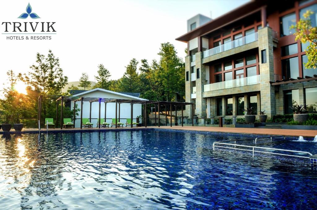 une grande piscine en face d'un bâtiment dans l'établissement Trivik Hotels & Resorts, Chikmagalur, à Chikmagalur