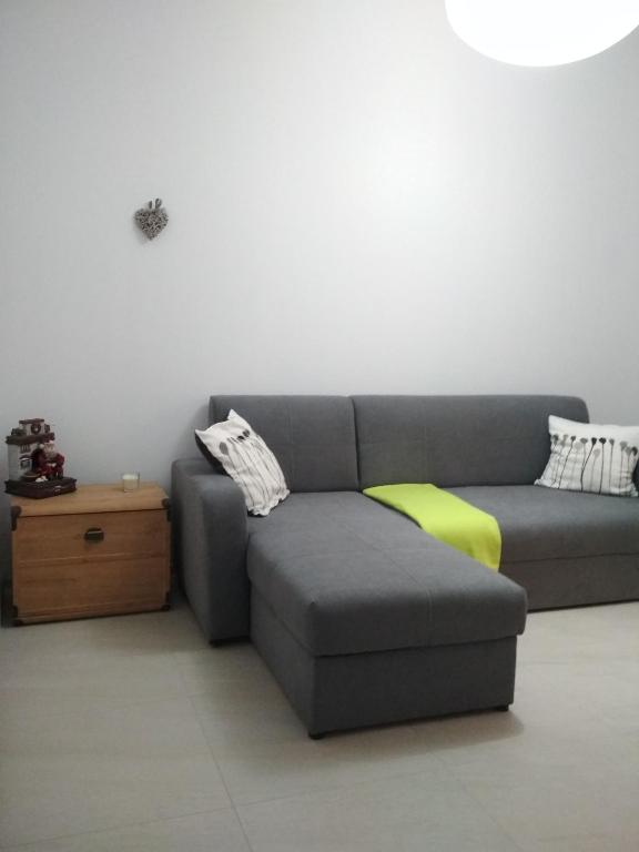 a living room with a gray couch and a table at Apartament Scorpion Modlin in Czosnów