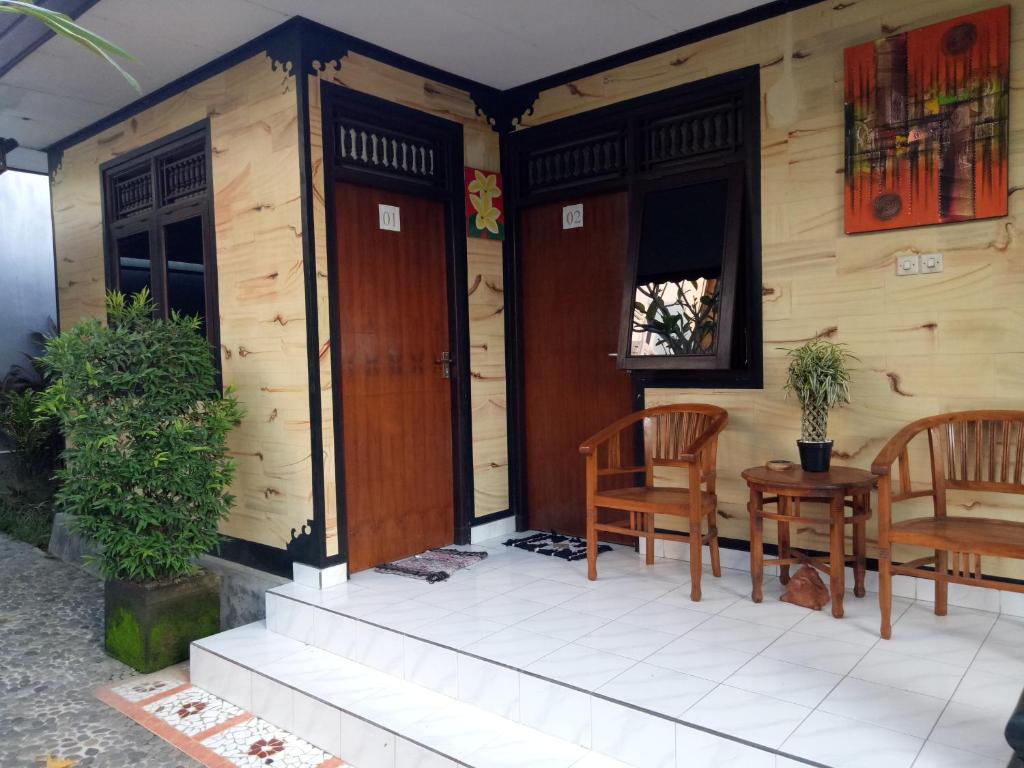 una piccola casa con due sedie e un portico di Wiran Homestay a Canggu