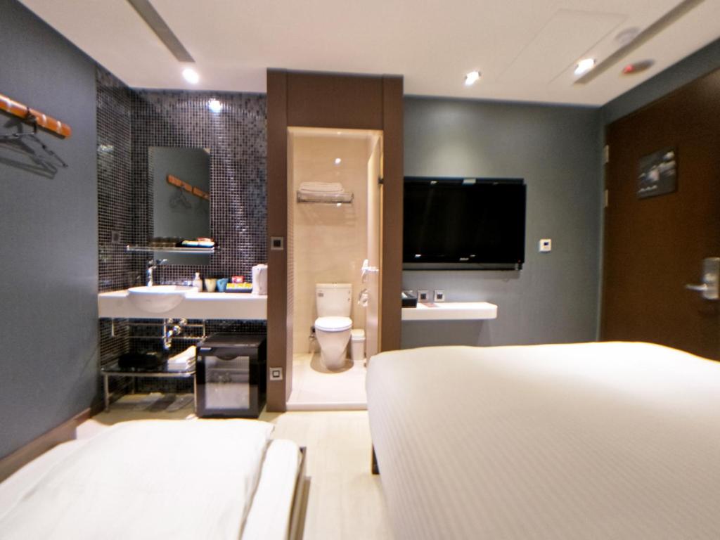 a bedroom with a bed and a bathroom with a tv at Beauty Hotels Taipei - Hotel B6 in Taipei