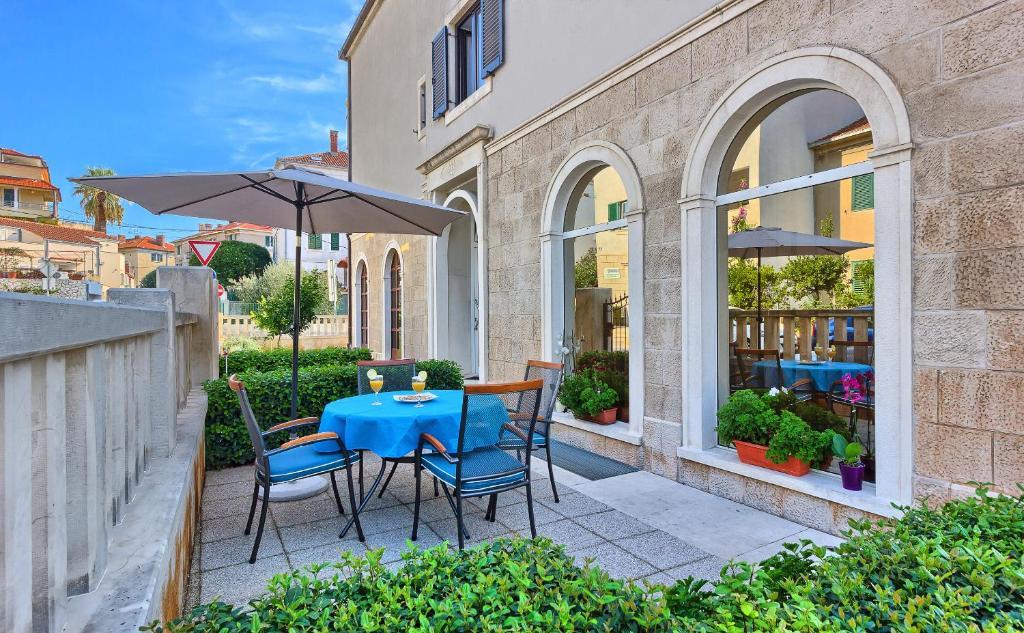 a patio with a table and chairs and an umbrella at Sweet Home Apartment Split in Split