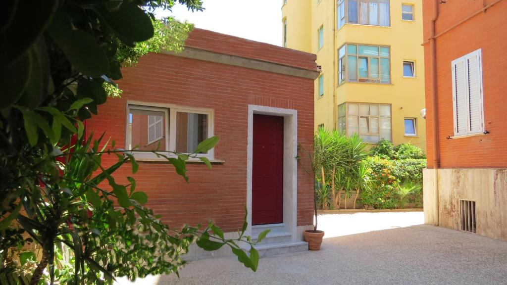 un edificio in mattoni rossi con una porta rossa e alcuni edifici di The Red Box Roma on the Beach a Roma