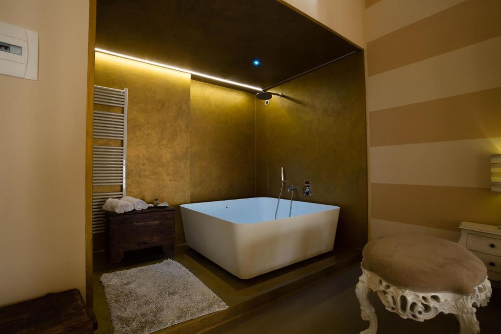 un bagno con una grande vasca in una stanza di Alessi Hotel Trattoria a Desenzano del Garda