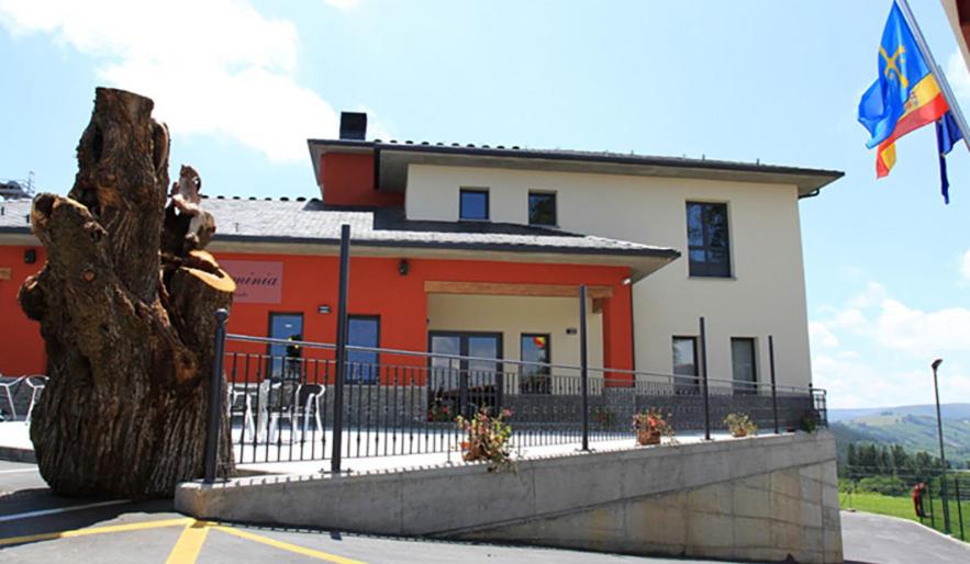 un edificio con una bandera delante de él en Albergue Restaurante Casa Herminia, en El Campiello