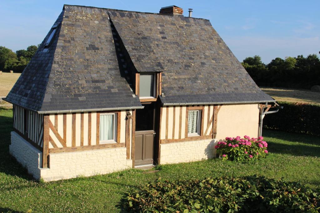 una pequeña casa con techo de gambrel en La Bouillerie du Clos, en Branville