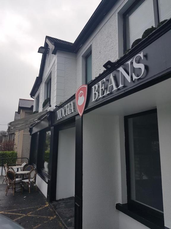 un edificio con un cartel para una tienda de vigas en Mocha Newcastle, en Galway