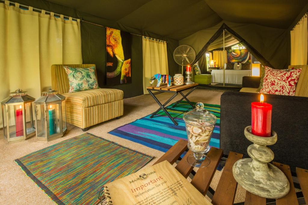 a living room with a tent with a candle and a table at Mahoora Wilpattu - by Eco Team in Wilpattu