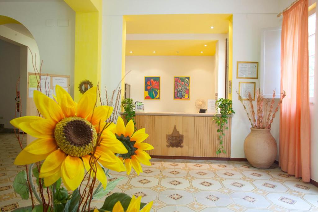 a lobby with yellow flowers in the middle of a room at Hotel Moderno in Guardia Piemontese Terme