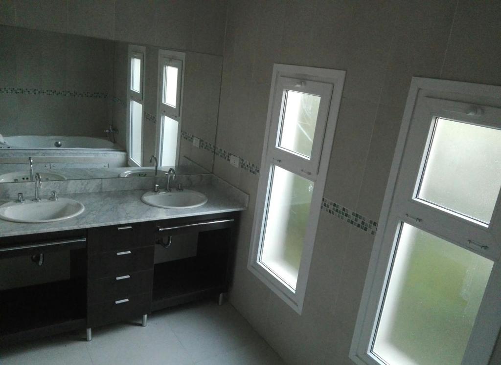 a bathroom with two sinks and two windows at Hosteria Ruphay in Tandil