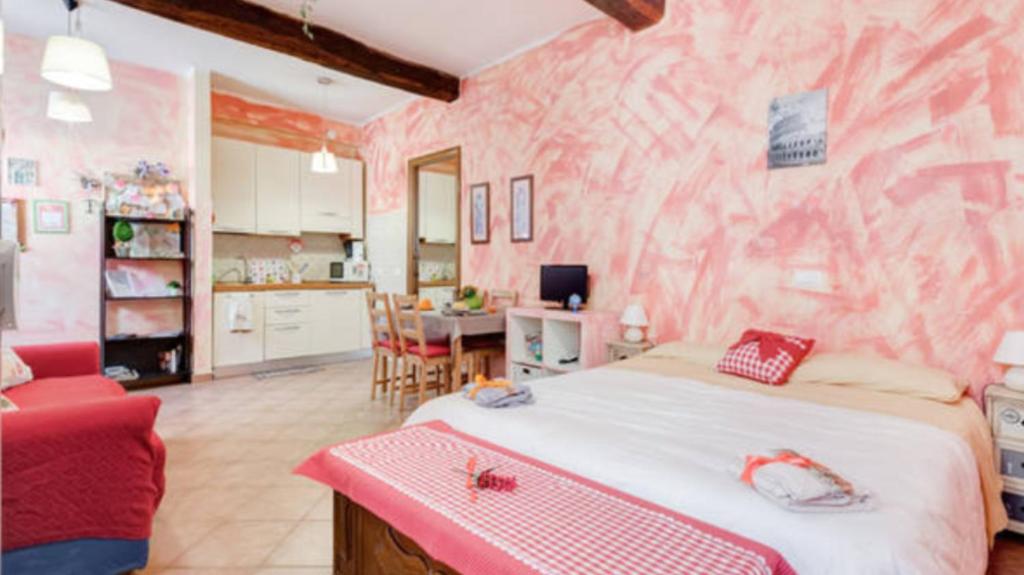 ローマにあるMaria De La Mercè Apartmentのピンクの壁のベッドルーム(ベッド付)
