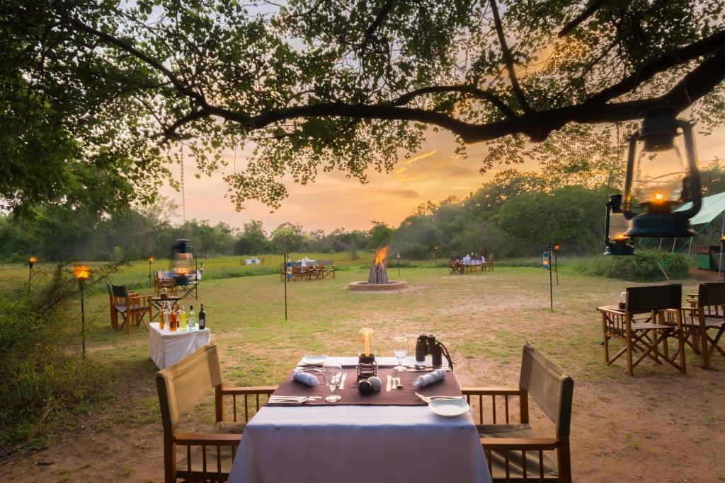 a table set up for a party in a field at Mahoora Wilpattu - by Eco Team in Wilpattu