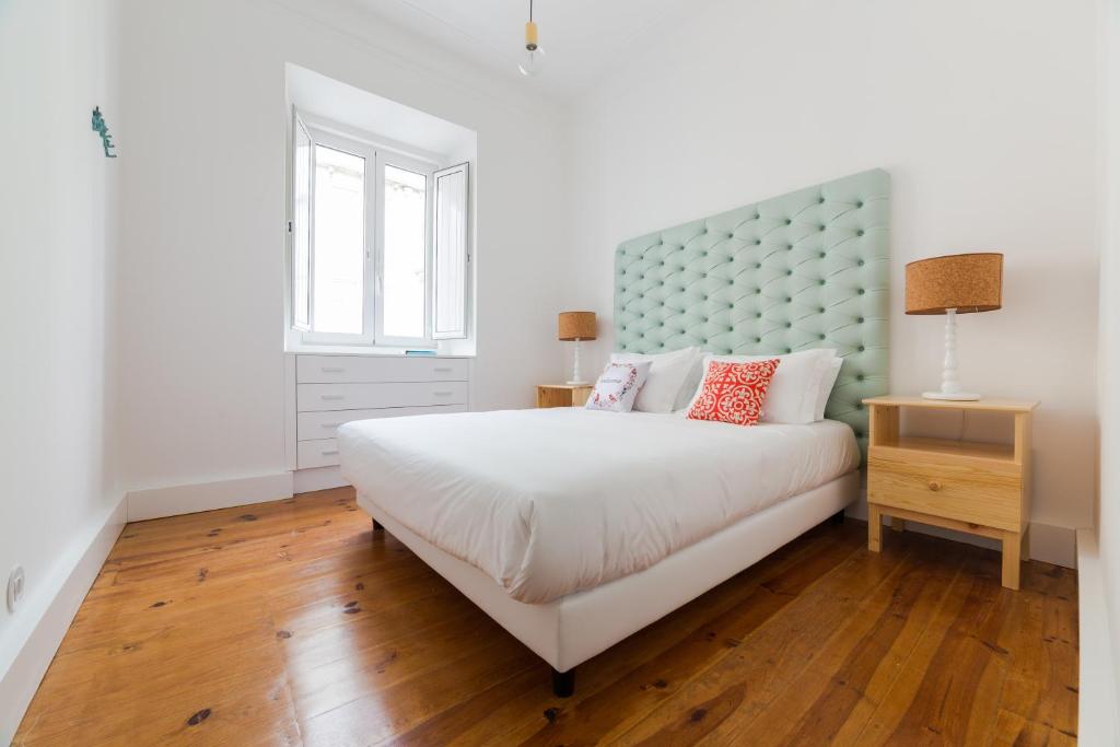 リスボンにあるLisbon heart 1-cozy Flat-Family Friendlyのベッドルーム1室(大型ベッド1台、青いヘッドボード付)