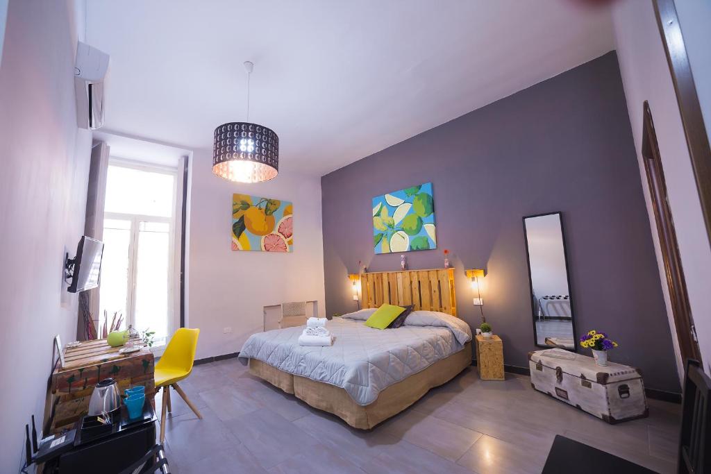 1 dormitorio con 1 cama grande y pared azul en Le 4 Stagioni Dante's Suites H Napoli Centro, by ClaPa Group, en Nápoles