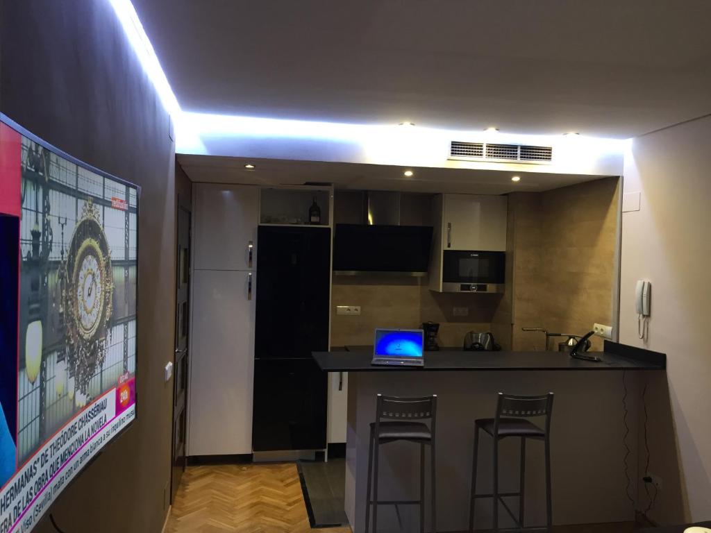 a room with a kitchen with a laptop on a counter at Madrid Paseo de la Castellana in Madrid