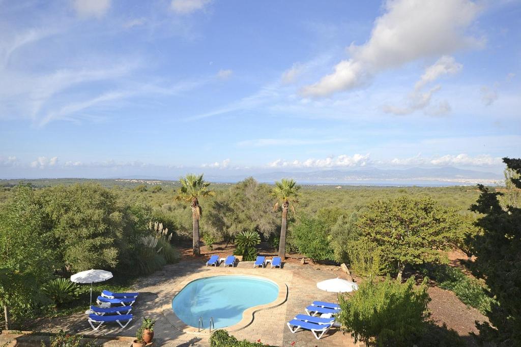 een uitzicht over een zwembad met stoelen en parasols bij Villa Son Granada in Llucmajor