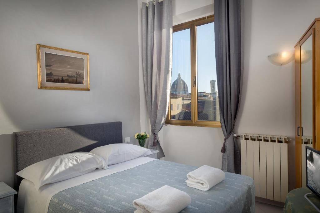 フィレンツェにあるAdre Majestic View ! Center of Florence !のベッドと窓が備わるホテルルーム