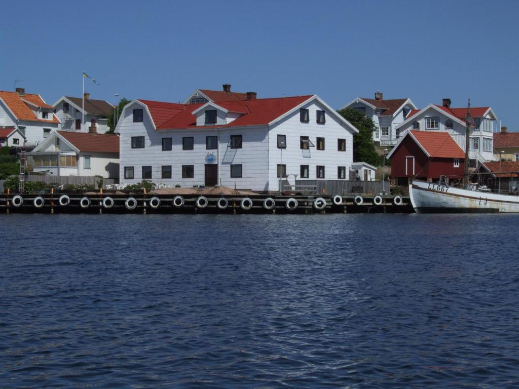 un grupo de casas y un barco en el agua en Hotell Fisketången en Kungshamn