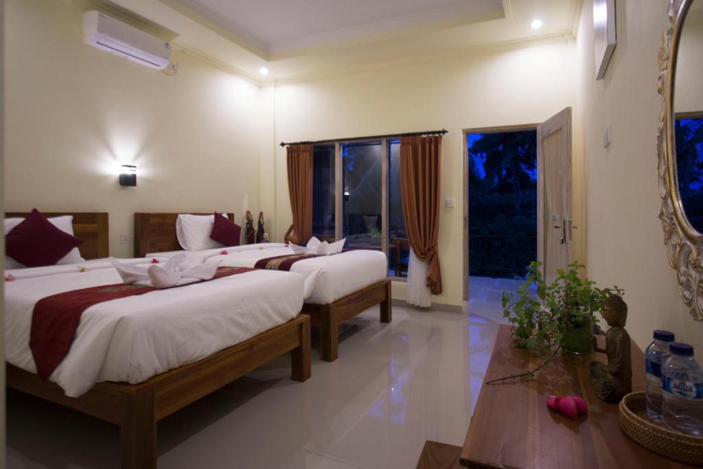 Postel nebo postele na pokoji v ubytování Vinayaka Ubud