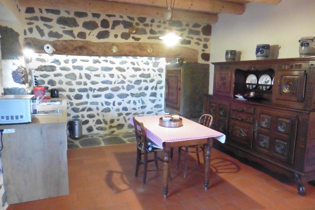 uma cozinha com uma mesa e uma parede de pedra em La Loge em Sanssac-lʼÉglise