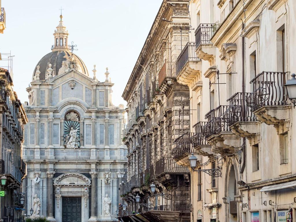 ein Gebäude in der Mitte einer Straße mit Gebäuden in der Unterkunft Duomo Suites & Spa in Catania